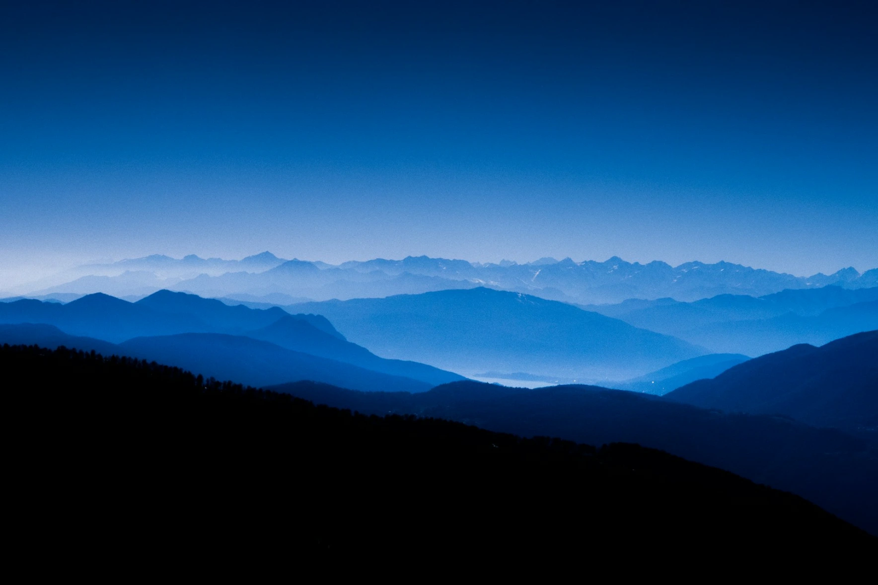 Blue mountain coffee Layered blue mountain silhouettes fading into a misty horizon under a clear sky