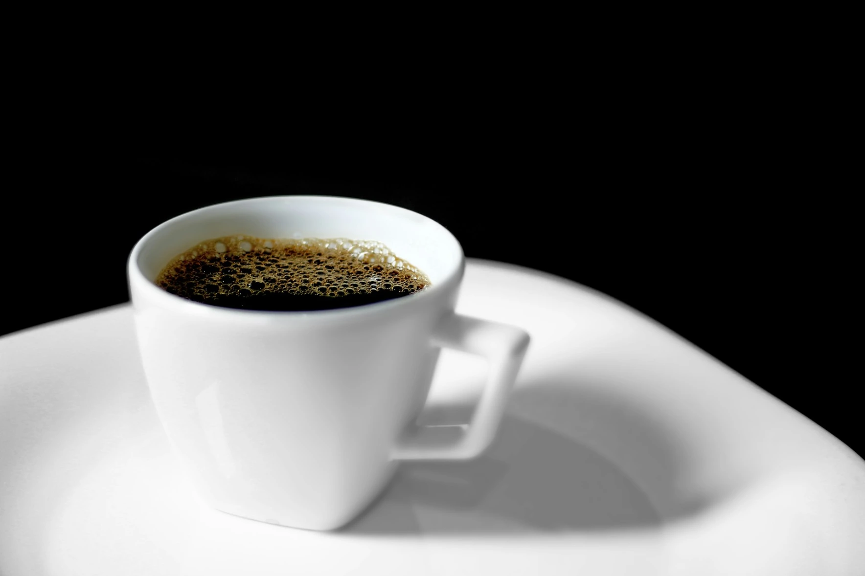 black coffee cup by wscafe A cup of coffee sitting on top of a white plate